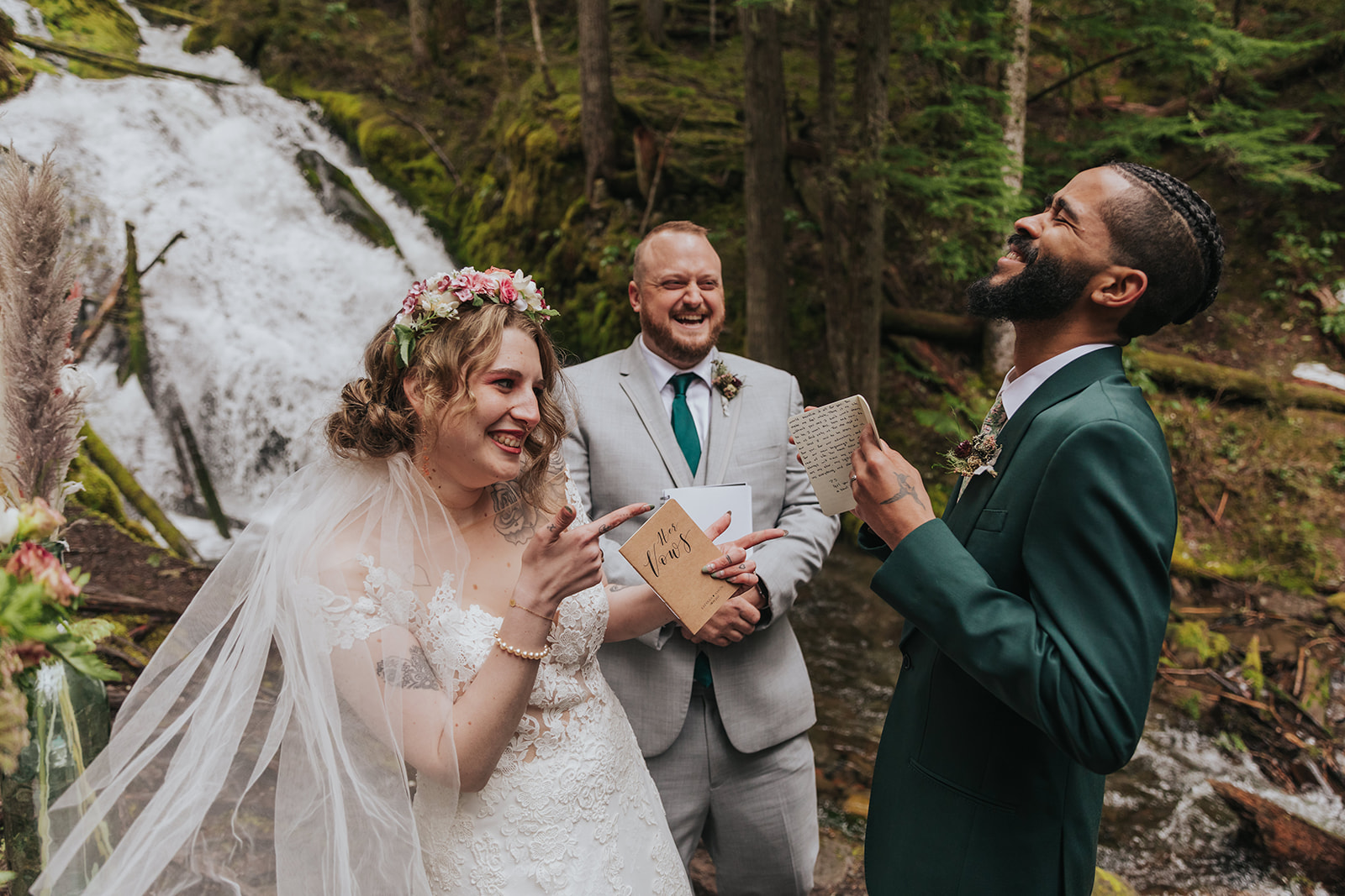 should we elope - a couple laughs during their elopement ceremony in front of a waterfall