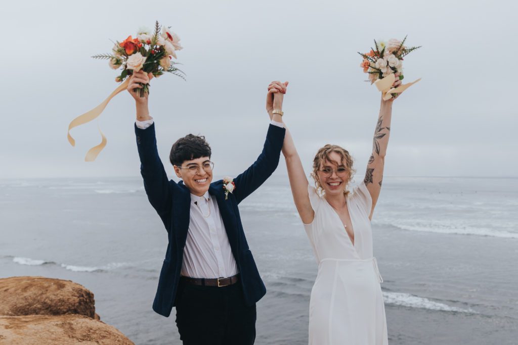 Couple holding their elopement bouquets in the air