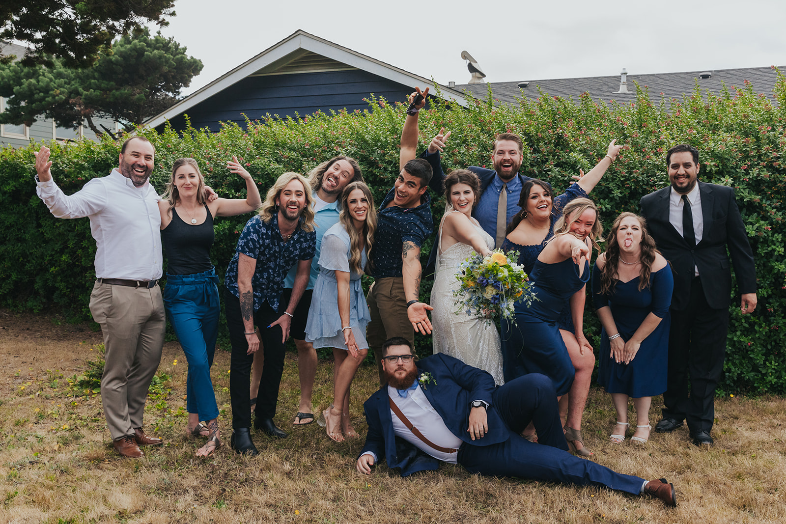 A fun group photo of a wedding party laughing and smiling at the camera