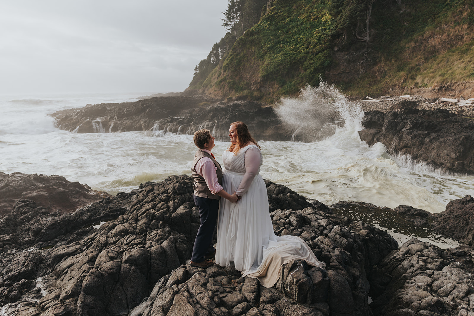 A couple stands amongst a rocky cove on their "Just Us" elopement day.