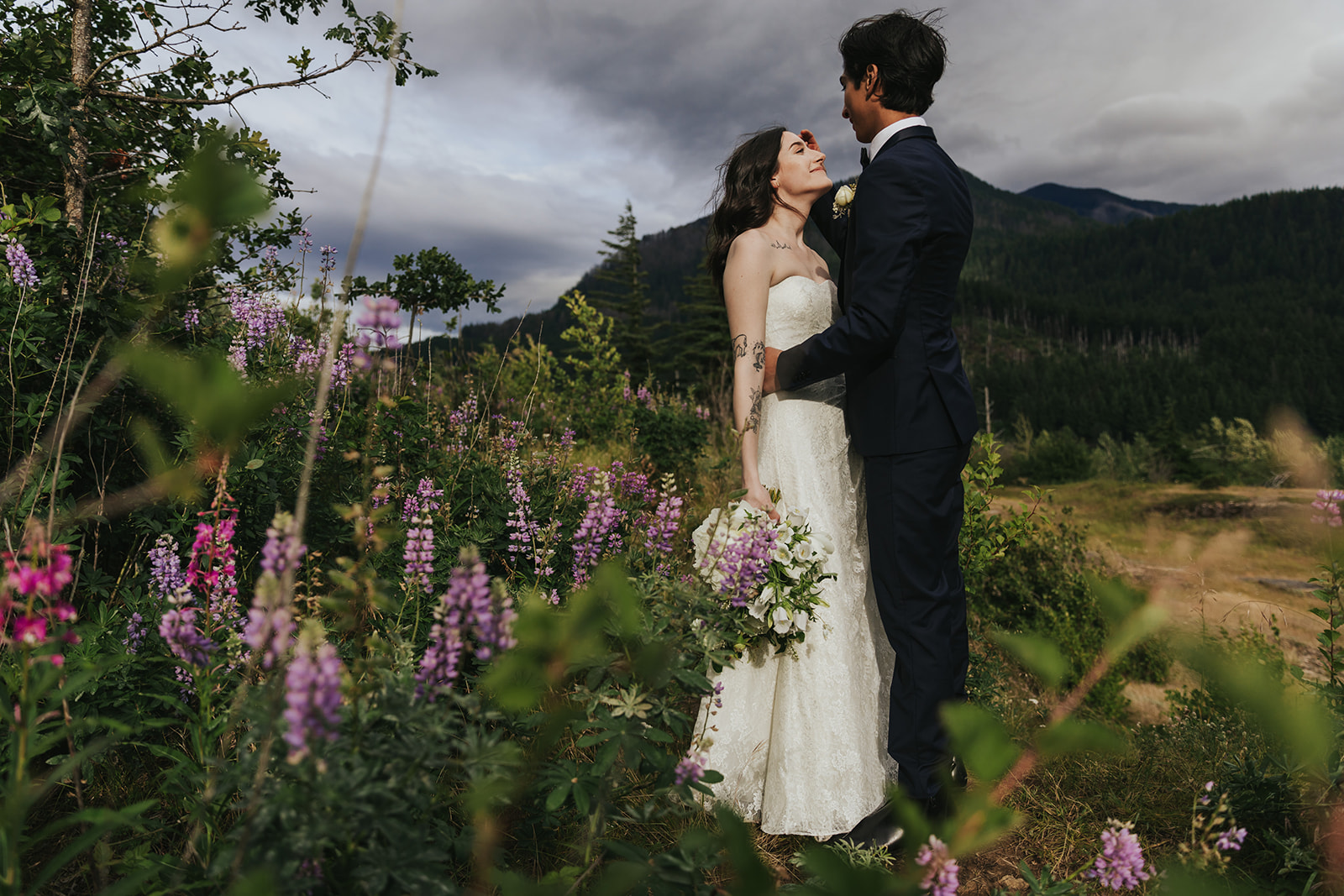 A couple stands amongst lupines and wildflowers for their Columbia River Gorge elopement.
