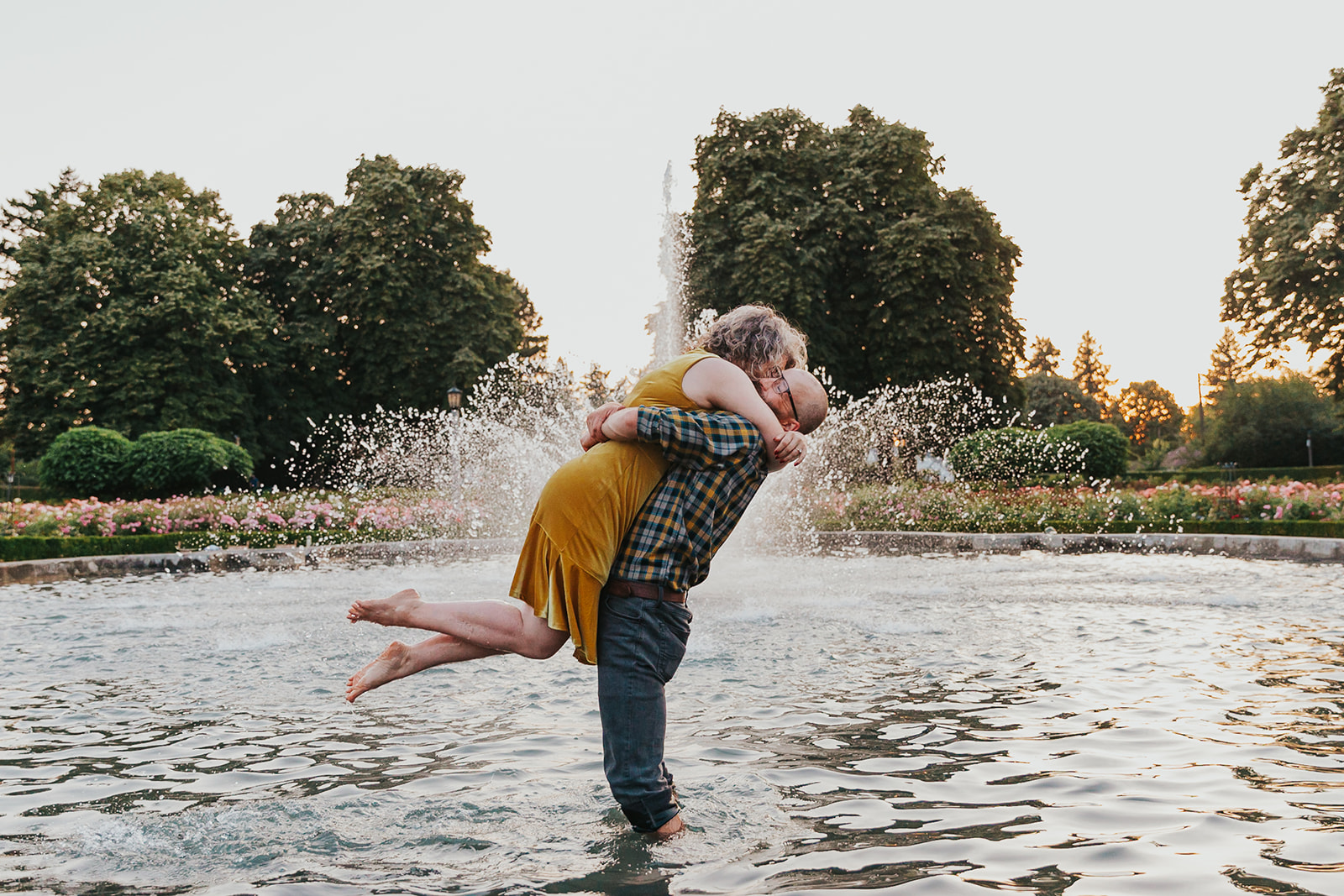 A couple play in the fountain at Peninsula Park, a popular Portland engagement photo location.