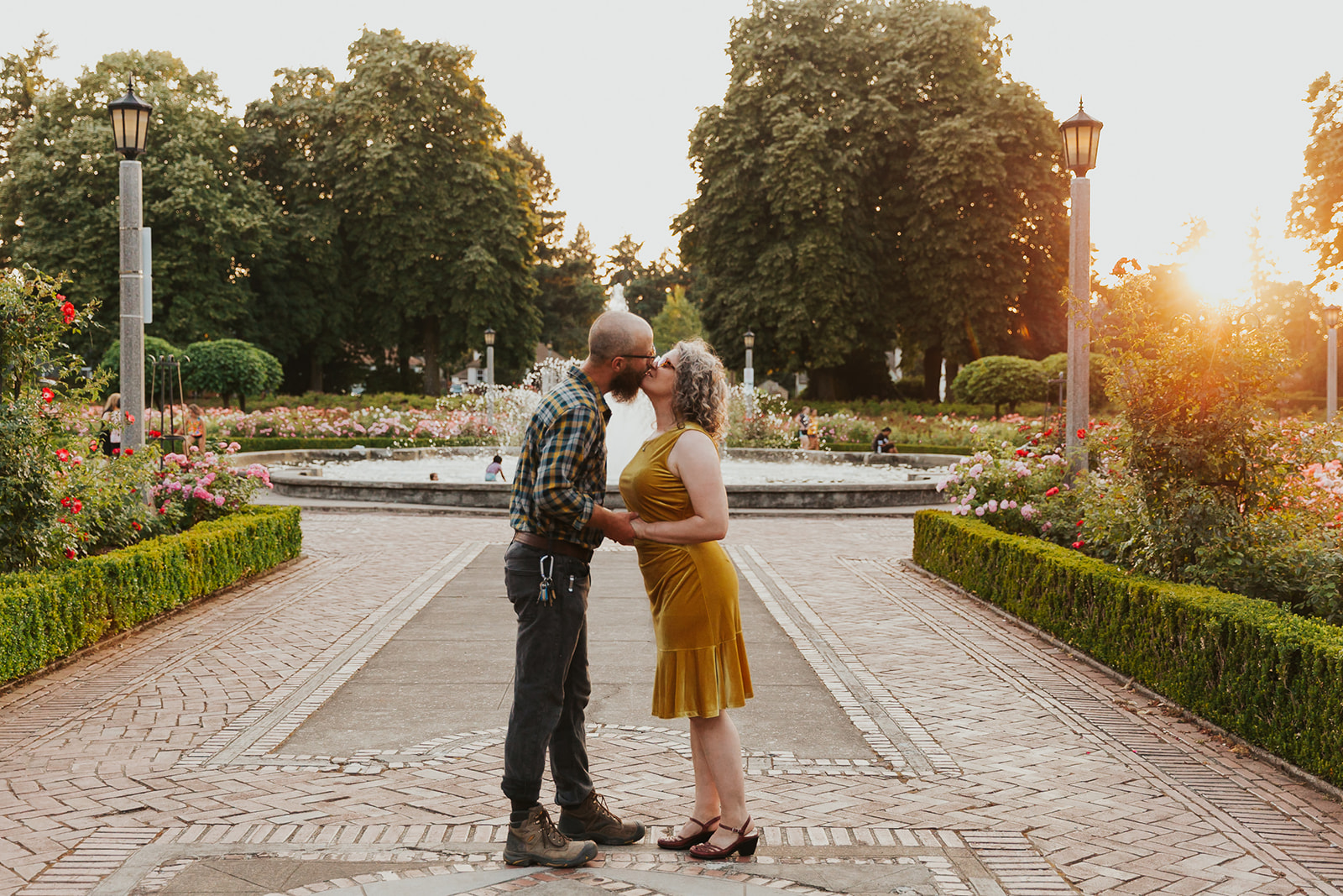 A couple kisses at Peninsula Park, a popular Portland engagement photo location.