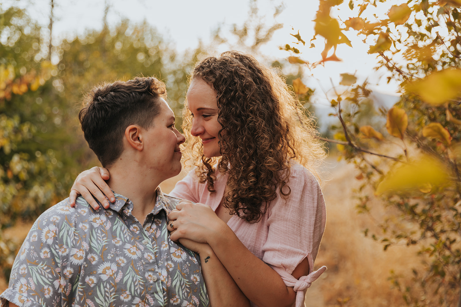 A couple are holding hands and smiling at each other