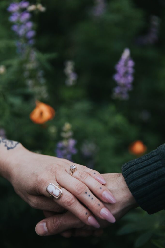 A pair of hands on top of each other showing an engagement ring